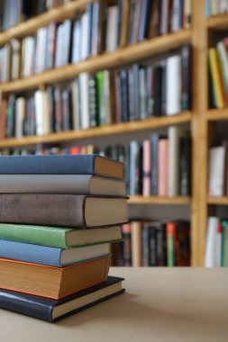 Kitaplar ve gözlükler kütüphanedeki ahşap masada.