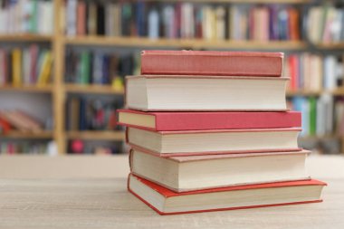 Tahta masanın üzerinde bir yığın kitap var.