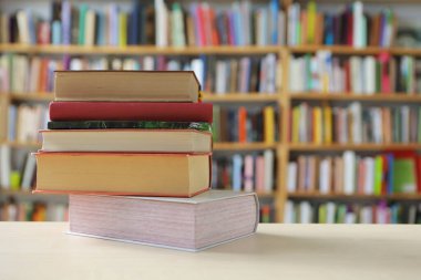 Tahta bir duvarın önünde yığınla kitap..