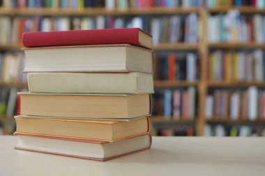 Tahta masadaki kitap yığını.