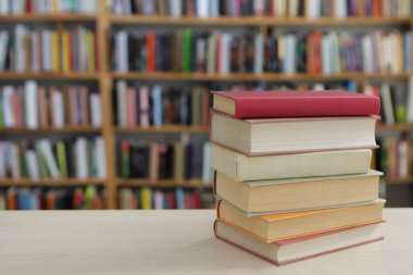 Kütüphanedeki masanın üzerinde kitap yığını