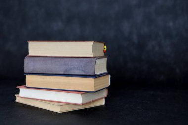 Siyah arkaplan üzerine kitap yığını.