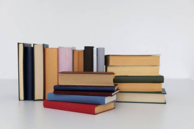 Beyaz ahşap zemin üzerine bir yığın farklı kitap