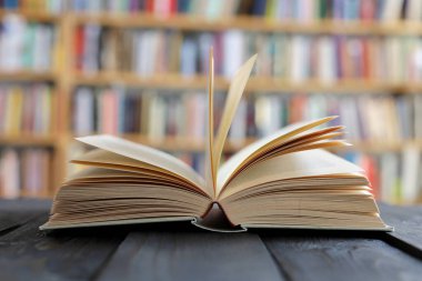 Kütüphanedeki ahşap bir masanın üzerinde açık bir kitap