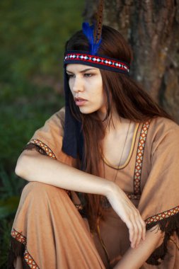 Yerli Amerikan boho elbisesi içinde rüzgarlı bir günde yürüyen genç bir kadının ön portresi..