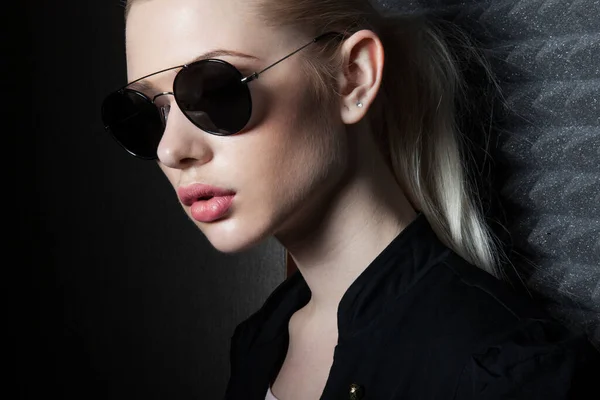 Szoros portré egy szexi szőke nő modell smink és lófarok frizura, visel fekete ing és napszemüveg. — Stock Fotó