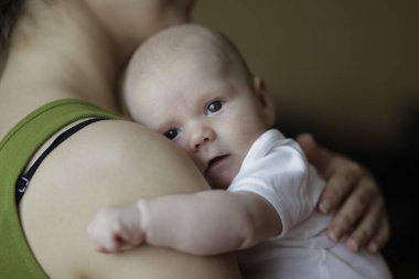 Genç ve mutlu bir babanın, tatlı, tapılası bebeğine sarılıp öptüğünün yakın plan portresi. Kapalı çekim.