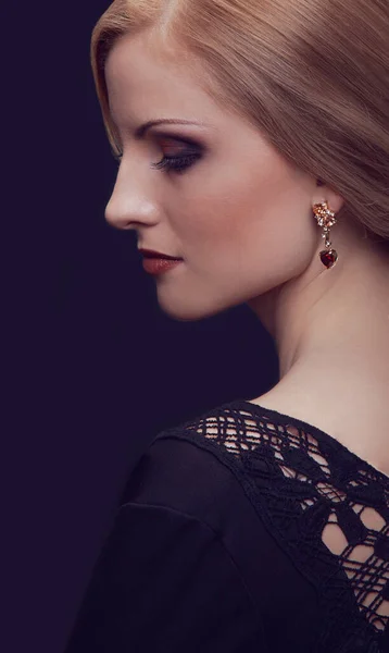 Närbild porträtt av vackra kvinnliga modellen med blont hår med make-up och frisyr på svart bakgrund. — Stockfoto