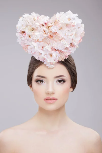 Skönhetsporträtt framifrån. Vacker flicka med vårblommor och bara axlar. Kreativ make up och frisyr. — Stockfoto