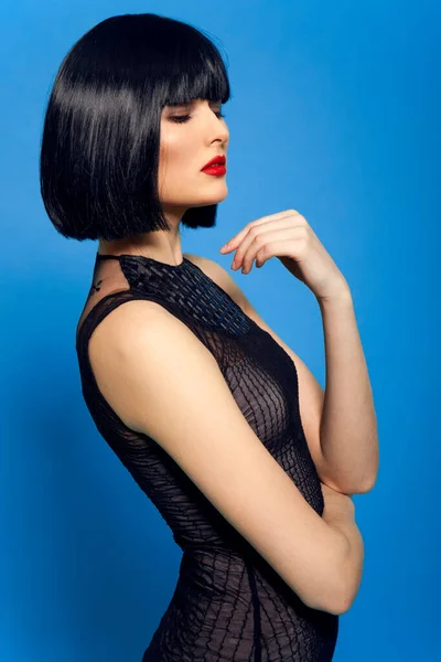 赤い唇を持つ若い美しい黒髪の女性のクローズアップファッションの肖像画、青の背景. — ストック写真