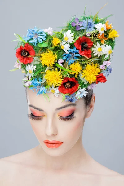 Närbild skönhetsporträtt. Vacker flicka med våren färgglada blommor. Skönhetsansikte. Kreativ make up och frisyr. — Stockfoto