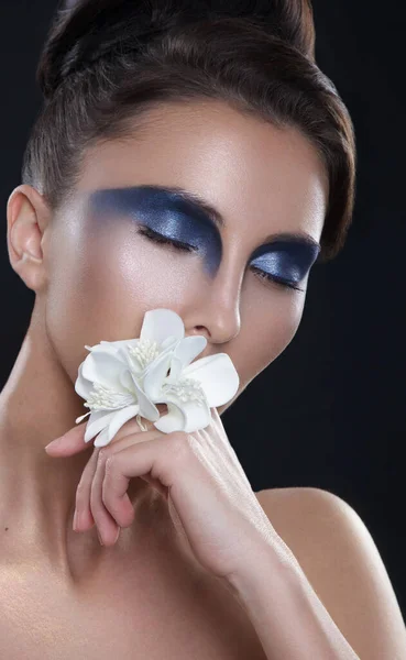 Brunett kvinna ansikte närbild porträtt med rökig blå ögon makeup över svart bakgrund. — Stockfoto