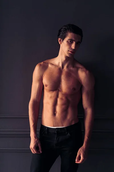 Frontalporträt eines fitten, athletischen jungen Mannes auf dunkelgrauem Hintergrund. — Stockfoto