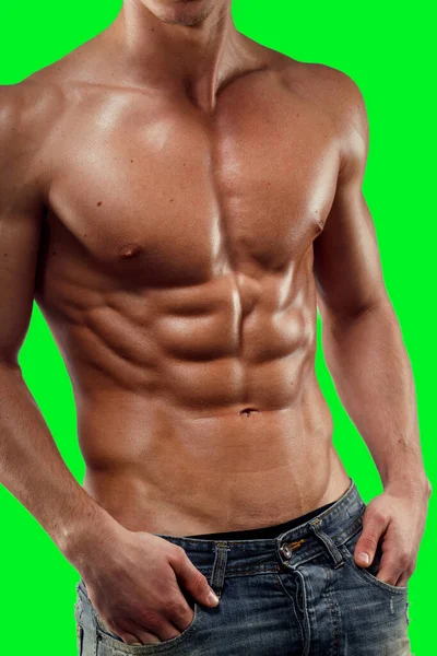Fechar-se de um homem sem camisa de jeans, mostrando um seis pacote abs alívio abdominal, de uma tela verde cromo fundo chave. — Fotografia de Stock