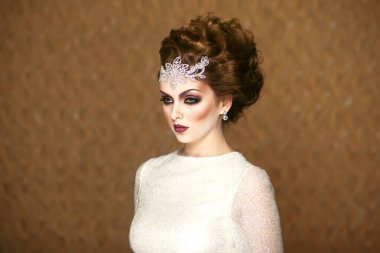 Güzel bir gelinin ön portresi, makyajlı ve saç stili gelinlikli, beyaz gelinlikli, yandan bakan..