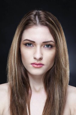 Makyajlı, siyah arka planlı, çıplak omuzlu güzel bir kız..