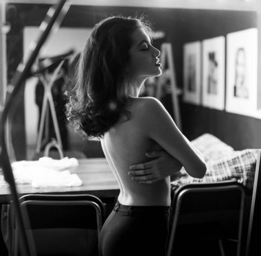 Model portresi aynanın içinde, ampullerle birlikte. Karanlık yatak odasında çıplak güzel bir kadının ayna yansıması..