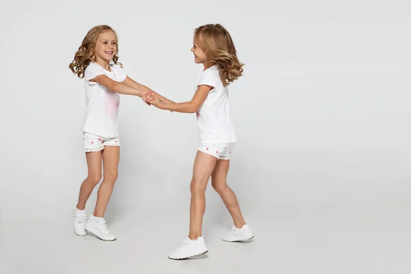 Gelukkige Grappige Tweelingzusjes Witte Kleren Dansen Geïsoleerd Witte Achtergrond Kinderen — Stockfoto