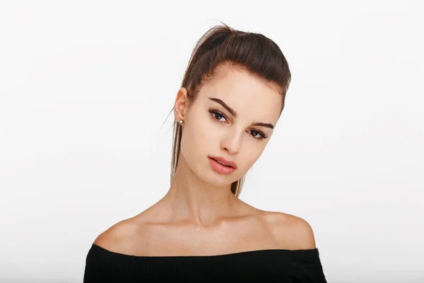 Ön tarafta duran beyaz arka planda kameraya bakan kadın model. Esmer at kuyruklu güzel bir kadın..
