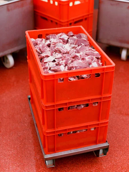 Cuadro del marco de una caja roja de plástico con carne cruda fresca picada, trabajador dispuesto un almacenado en una fábrica de carne, industria. — Foto de Stock