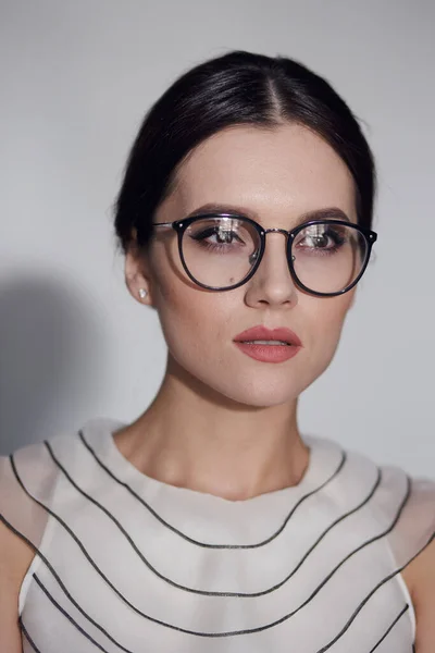 Schönheitsporträt einer jungen eleganten Frau in Brille, isoliert auf weißem Hintergrund. Vertikale Ansicht. — Stockfoto