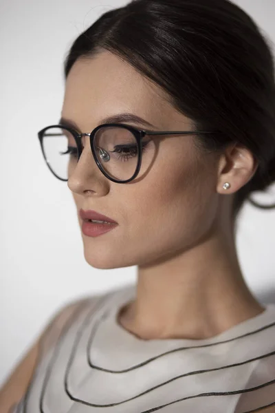 Portrait de profil beauté d'une jeune femme élégante en lunettes, isolée sur un fond blanc. Vue verticale. — Photo