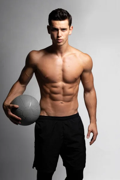 Imagem frontal de um belo jovem fitness homem forte desnudado desportista muscular jogador de basquete isolado em fundo cinza. — Fotografia de Stock