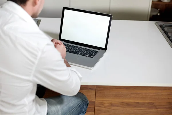 Ofiste masada otururken dizüstü bilgisayar kullanan normal giyinmiş yakışıklı bir adamın dikiz görüntüsü. Yatay görünüm. — Stok fotoğraf