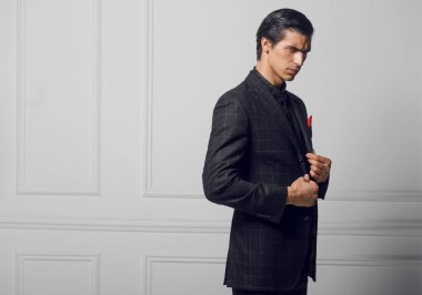Portrait of a confident business man in black suit with red silk scarf in pocket, over white background.