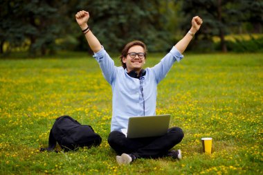 Parktaki gülümseyen genç bir adamın mutlu hali. Eğitici kavram.