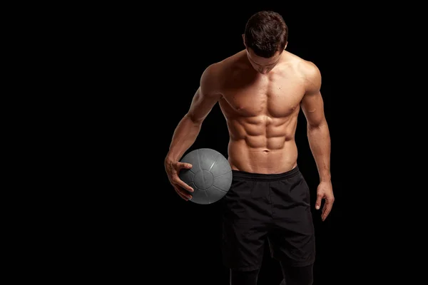 Portret seksownego mężczyzny z muskularnym ciałem trzymającego piłkę do koszykówki, pozowanie w studio, odizolowane czarne tło. — Zdjęcie stockowe