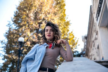 Taş merdivenlerde oturan genç ve çekici bir kadın model..