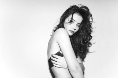 Siyah-beyaz, siyah iç çamaşırlı çekici bir kadının beyaz arka planda, stüdyoda poz verişi..