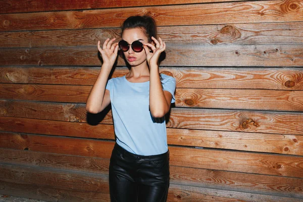 Atraktivní Mladá Dívka Slunečními Brýlemi Modrým Tričkem Koženými Kalhotami Pózující — Stock fotografie