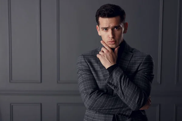 Retrato de joven guapo en chaqueta a cuadros posando en la posición de hombre de negocios, aislado sobre fondo gris. — Foto de Stock