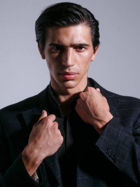 Siyah damalı yakışıklı bir adamın ön portresi yakasını beyaz bir arka planda izole ediyor..