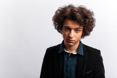 Harika saç stili olan genç bir adam, dalgın görünüyor, beyaz arka planda soyutlanmış. Yatay görünüm.