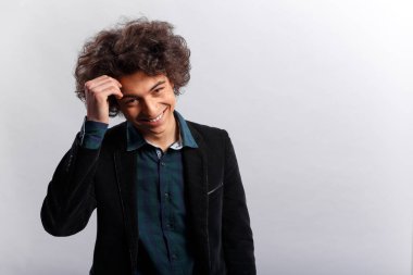 Stüdyo çekimi. Aşk yüzünden yüzü saklanmış ceketli gülümseyen bir çocuğun yatay görüntüsü. Metin için boşluk.