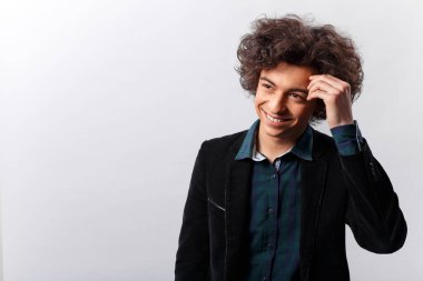 Stüdyo çekimi. Aşk yüzünden yüzü saklanmış ceketli gülümseyen bir çocuğun yatay görüntüsü. Metin için boşluk.