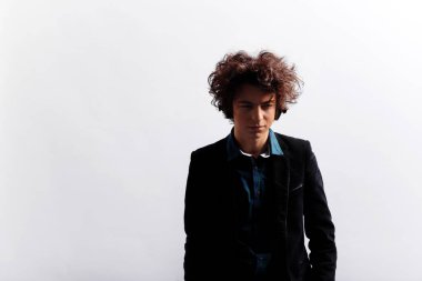 Somurtkan, üzgün, saçları harika, kulaklıklı, düşünceli, beyaz arka planda soyutlanmış genç bir adamın ön portresi. Yatay görüş. Boşluğu kopyala