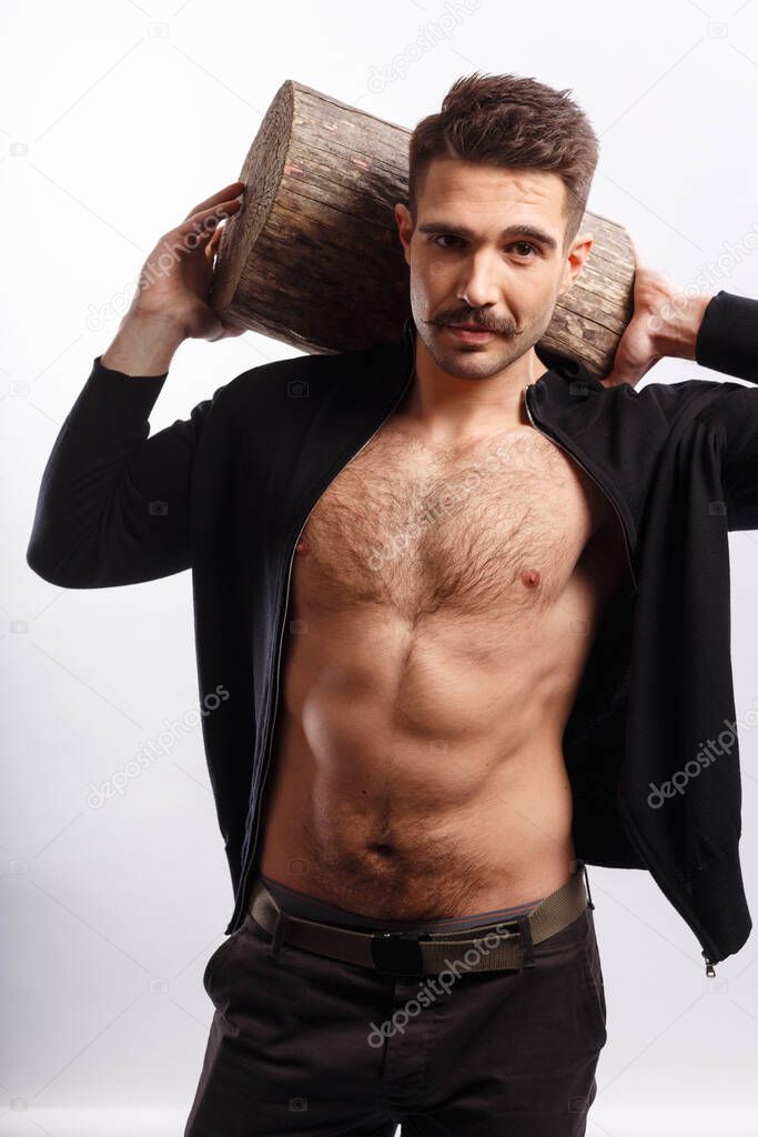 Vertical view. Strong, sportive young man with moustache and naked torso rise up a tree trunk above the head, over white background.