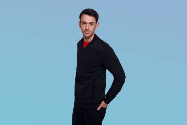 Koyu mavi kazaklı ve kot pantolonlu çekici esmer adam..