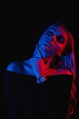 Moda portresi. Stüdyoda kırmızı ve mavi ışıklı genç kız.