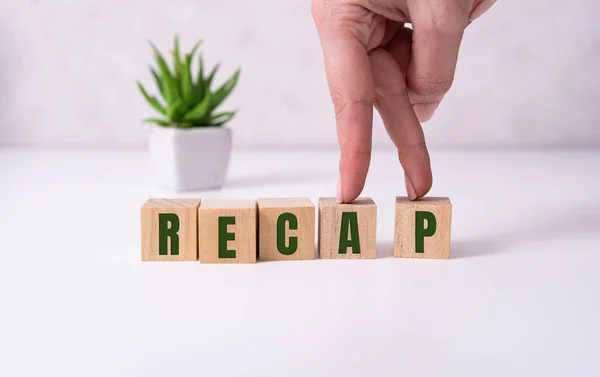 A koncepció a szó RECAP kockákon egy gyönyörű fehér háttér. — Stock Fotó
