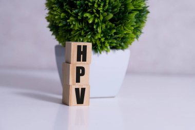 Tahta blokta HPV kelimesi yazıyor. Üst görünüm konseptiniz için masadaki HPV metni