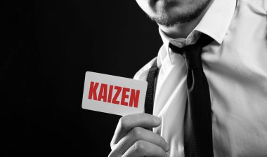 İş adamı elinde Kaizen yazılı bir kart tutuyor: