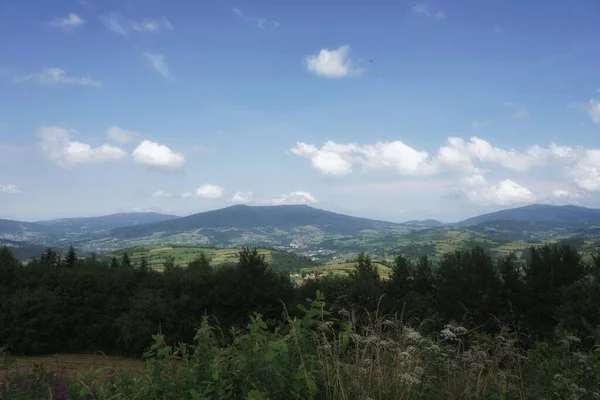 Temmuz 'da Beskids' ta, bir dağ çayırından vadiye ve tepelere, ormana, gökyüzüne ve bulutlara manzara