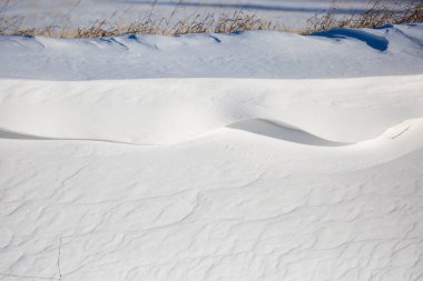 Close-up of snow wave patterns caused by wind, horizontal