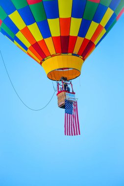 Marathon City, Wisconsin, ABD, 9 Temmuz 2021, Wausau 'nun batısında Tat N Parıltısı Balon Festivali. Havadaki ilk sıcak hava balonu, ABD bayrağı, dikey
