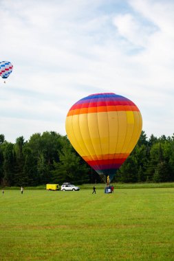 Marathon County, Wisconsin, ABD, 10 Temmuz 2021: Parlak Balon Festivali 'ni tat. Sıcak hava balonu Wisconsin 'in merkezindeki bir çiftçi tarlasına dikey iniş yapıyor.